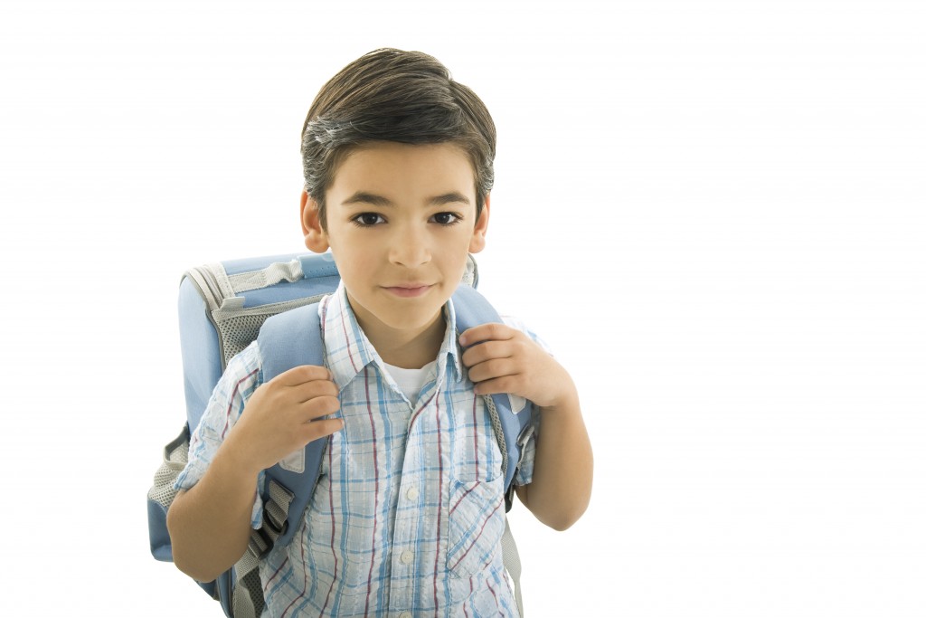 Portrait of young schoolboy with school-bag.Isolated on white.